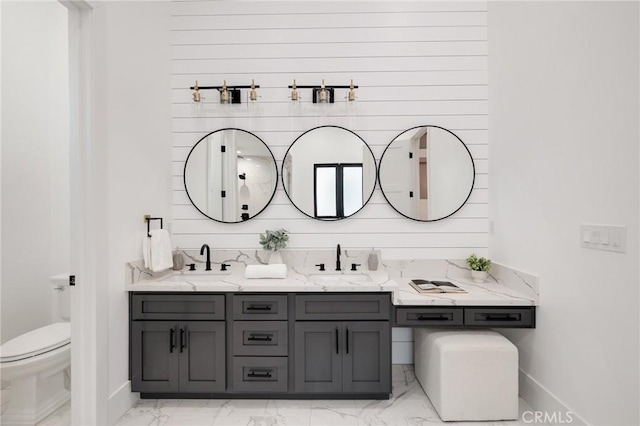 bathroom with wooden walls, vanity, and toilet