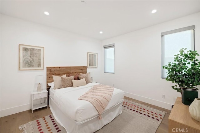 bedroom with multiple windows and wood-type flooring