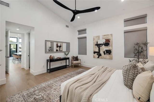 bedroom with high vaulted ceiling, light hardwood / wood-style floors, and ceiling fan