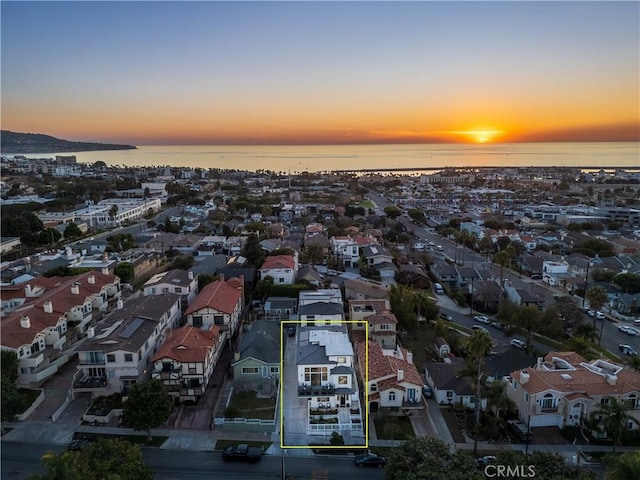 aerial view at dusk featuring a water view