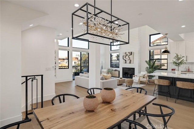 dining space with a wealth of natural light, a fireplace, and light hardwood / wood-style floors