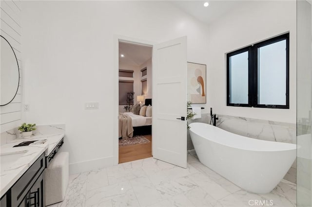 bathroom with vanity and a washtub