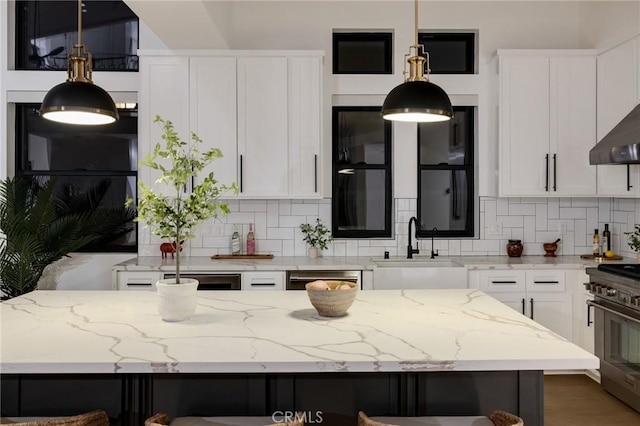 kitchen with white cabinets, light stone counters, and high end stove