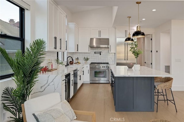 kitchen featuring white cabinets, decorative light fixtures, and high quality appliances