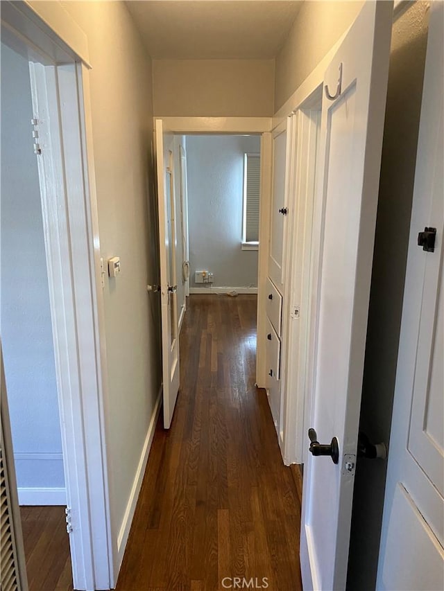 hallway with dark wood-style floors and baseboards