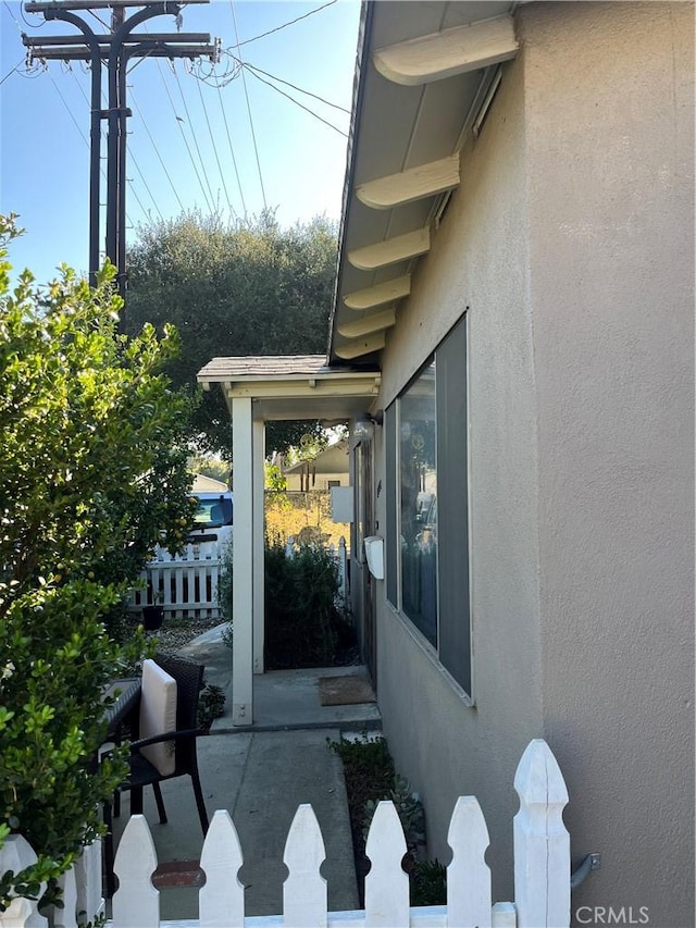 exterior space featuring stucco siding and fence