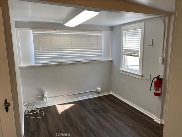 empty room with dark wood finished floors and baseboards