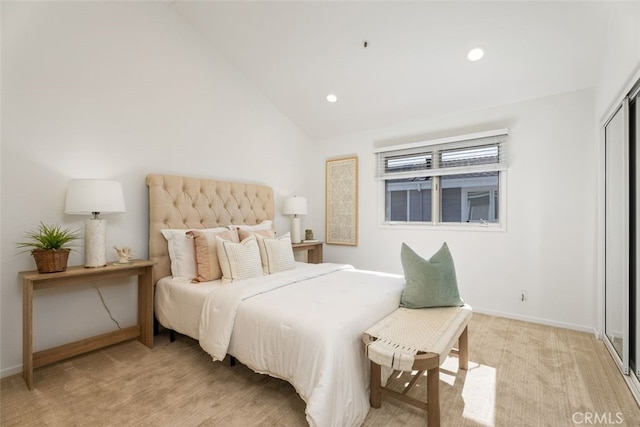 bedroom with lofted ceiling, light carpet, and a closet