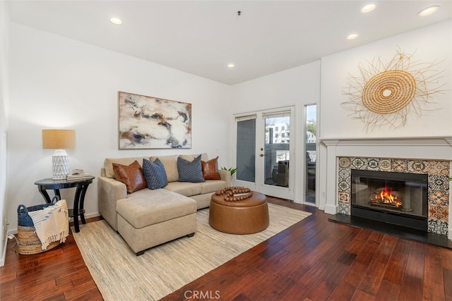 living room with hardwood / wood-style flooring and a tile fireplace