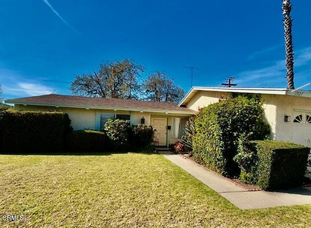 single story home featuring a garage and a front yard