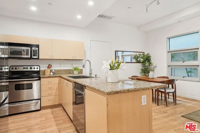 kitchen featuring sink, light hardwood / wood-style flooring, light brown cabinets, appliances with stainless steel finishes, and kitchen peninsula