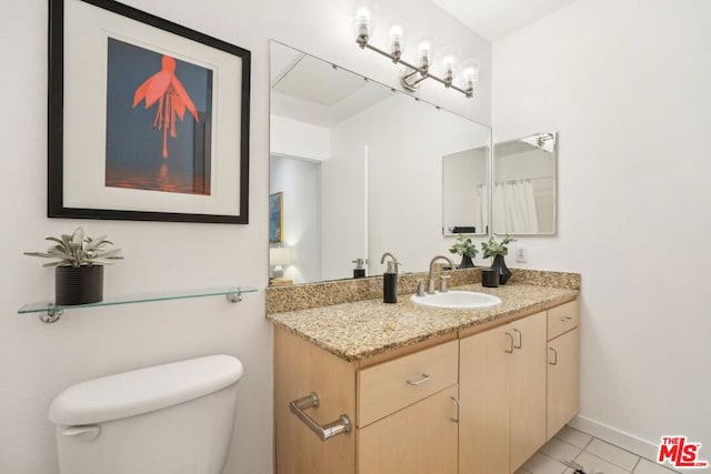 bathroom featuring vanity, tile patterned floors, and toilet