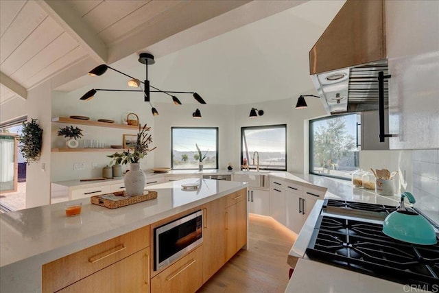 kitchen featuring light brown cabinetry, wooden ceiling, stainless steel microwave, light hardwood / wood-style floors, and white cabinets