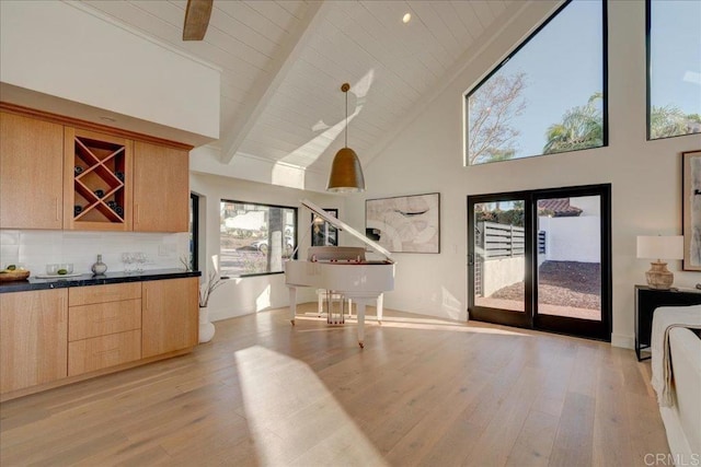 kitchen featuring light hardwood / wood-style flooring, hanging light fixtures, beam ceiling, backsplash, and high vaulted ceiling