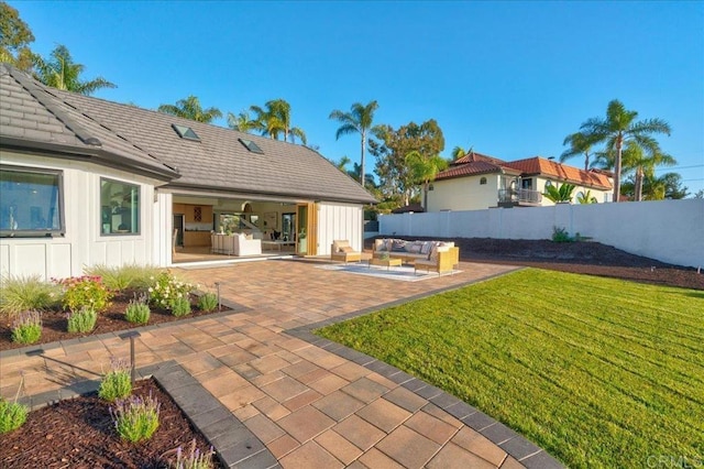 view of yard featuring exterior kitchen, an outdoor hangout area, and a patio area