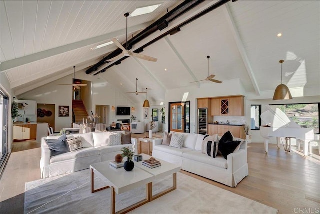 living room with beamed ceiling, ceiling fan, high vaulted ceiling, and light hardwood / wood-style floors