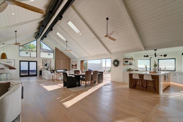 living room featuring ceiling fan, high vaulted ceiling, wood ceiling, and beam ceiling