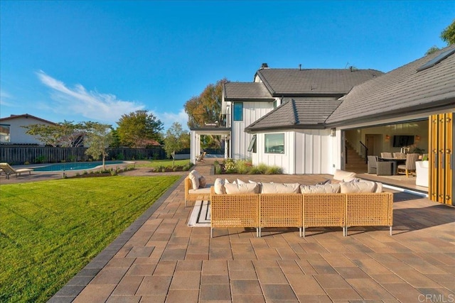 rear view of house featuring a fenced in pool, a yard, a patio area, and outdoor lounge area