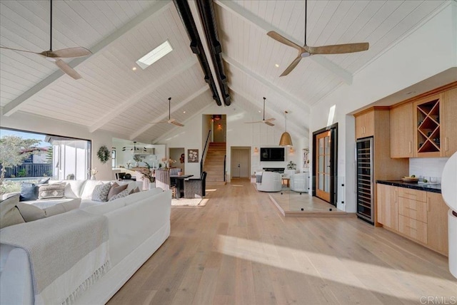 living room with wine cooler, high vaulted ceiling, light hardwood / wood-style flooring, ceiling fan, and beam ceiling