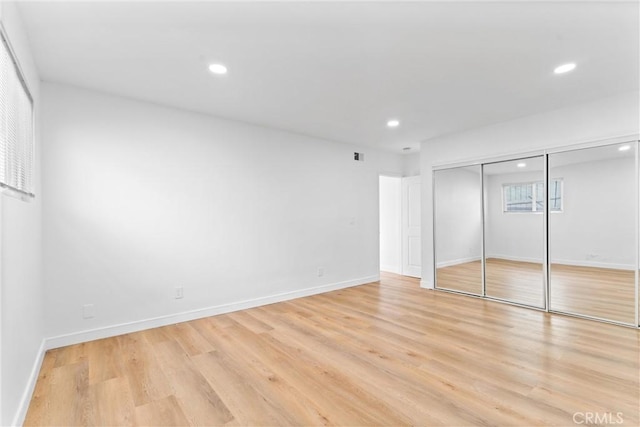 unfurnished bedroom featuring light hardwood / wood-style flooring and a closet