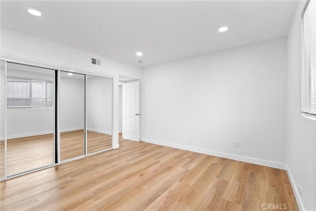 unfurnished bedroom featuring a closet and light wood-type flooring