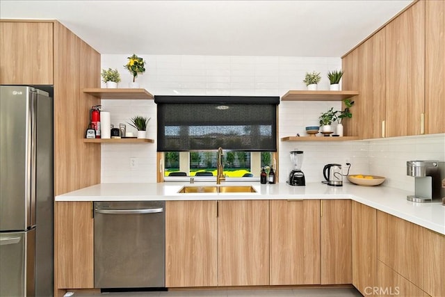 kitchen with appliances with stainless steel finishes, sink, light brown cabinets, and backsplash