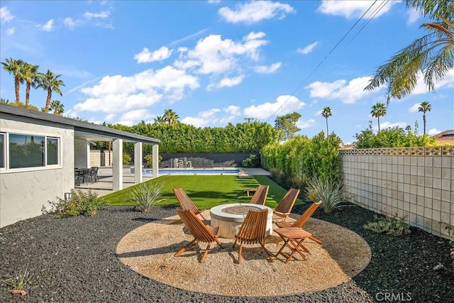 view of yard featuring a pool, an outdoor fire pit, and a patio