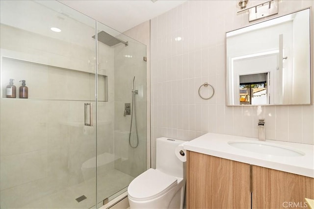 bathroom with tile walls, an enclosed shower, vanity, decorative backsplash, and toilet