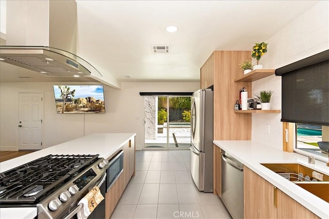 kitchen with light tile patterned floors, island exhaust hood, and appliances with stainless steel finishes