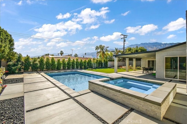 view of swimming pool with an in ground hot tub, a mountain view, and a patio area