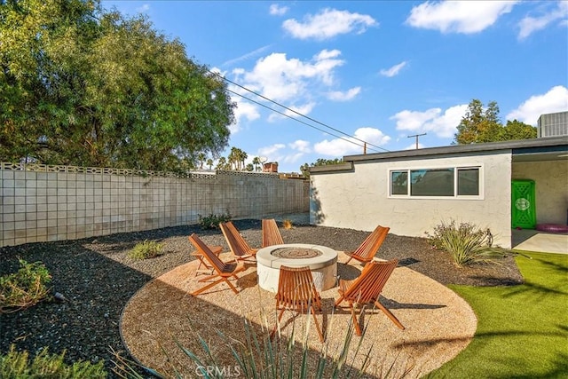 view of patio with cooling unit and an outdoor fire pit