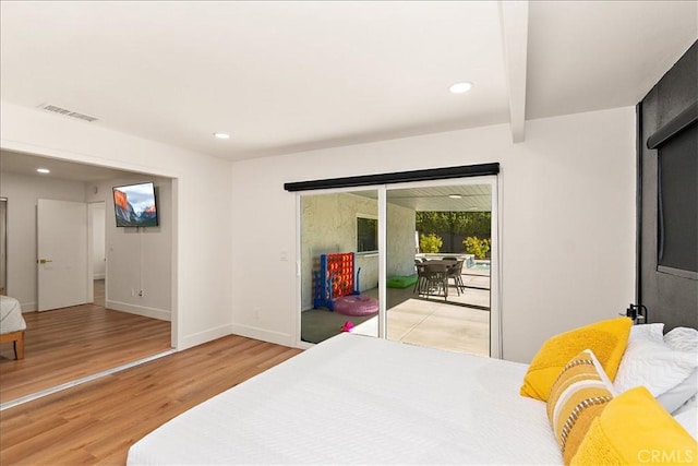 bedroom featuring hardwood / wood-style floors, access to outside, and beam ceiling