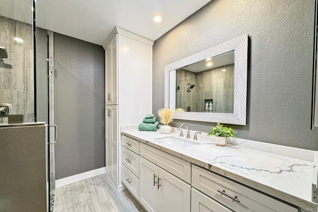 bathroom featuring an enclosed shower, vanity, and hardwood / wood-style floors