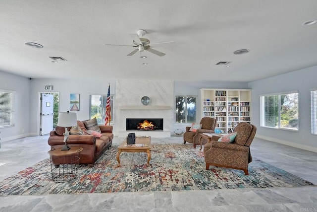 living room with a large fireplace and ceiling fan