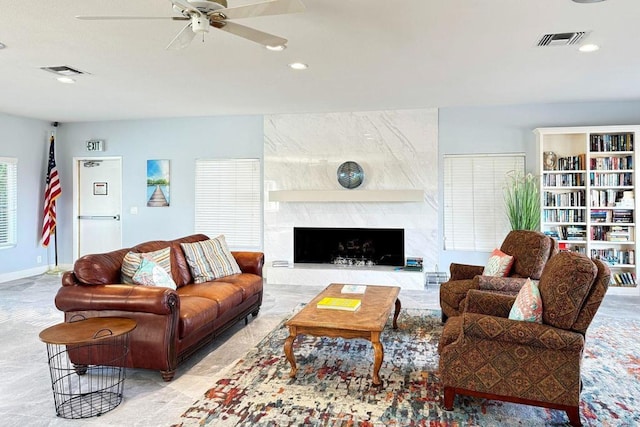 living room featuring ceiling fan and a high end fireplace