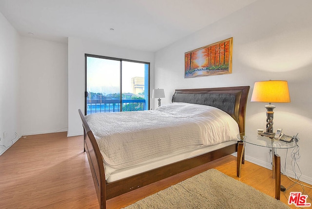 bedroom with access to exterior and light hardwood / wood-style flooring