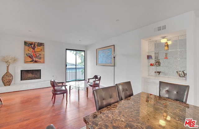 dining area with hardwood / wood-style floors and a high end fireplace