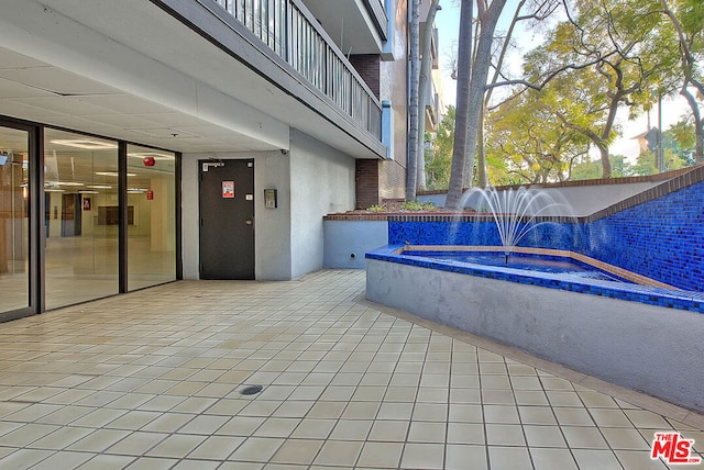 view of patio with pool water feature and a jacuzzi