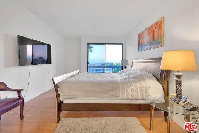 bedroom with hardwood / wood-style floors and access to outside