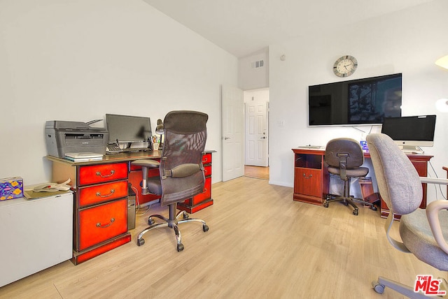 home office with lofted ceiling and light hardwood / wood-style flooring