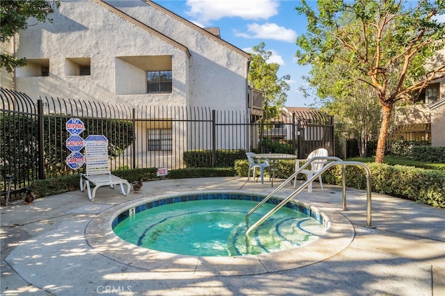 view of pool with a community hot tub and a patio