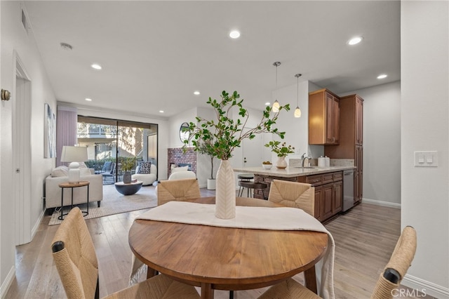 dining area with sink and light hardwood / wood-style floors