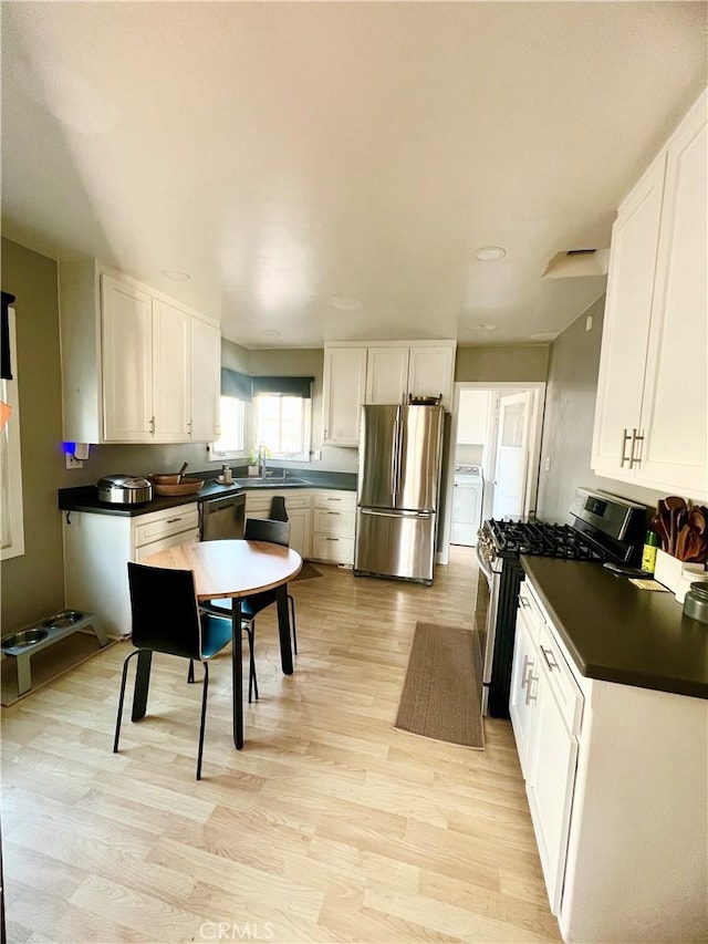 kitchen with white cabinetry, appliances with stainless steel finishes, light hardwood / wood-style floors, and sink