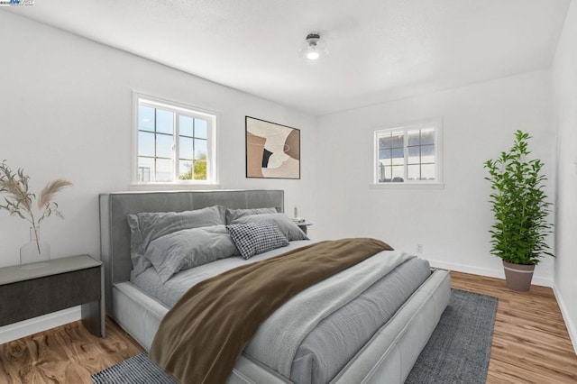 bedroom featuring multiple windows and light wood-type flooring