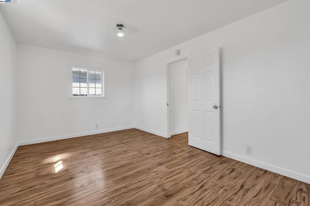 unfurnished room with wood-type flooring