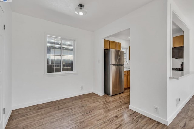 interior space featuring stainless steel refrigerator and light hardwood / wood-style flooring