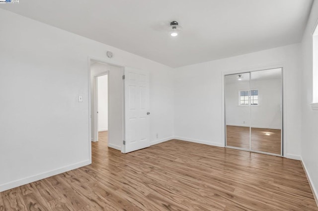 unfurnished bedroom featuring light hardwood / wood-style floors and a closet