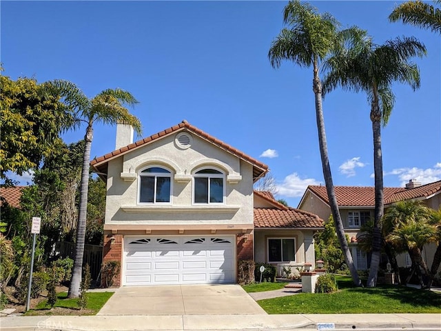 mediterranean / spanish-style home featuring a garage and a front lawn