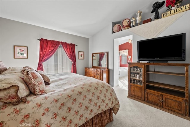 bedroom featuring connected bathroom, vaulted ceiling, and light colored carpet