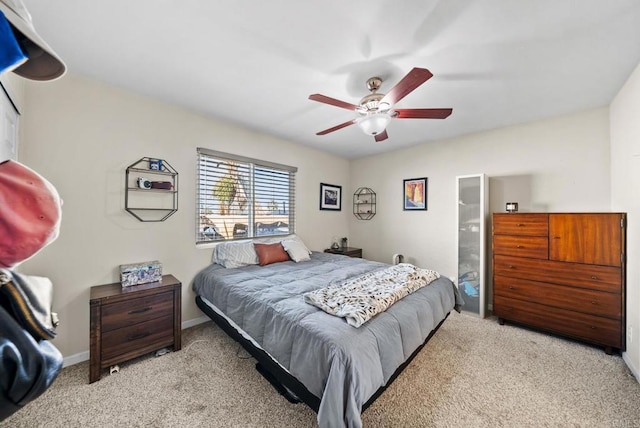 carpeted bedroom with ceiling fan and ensuite bath